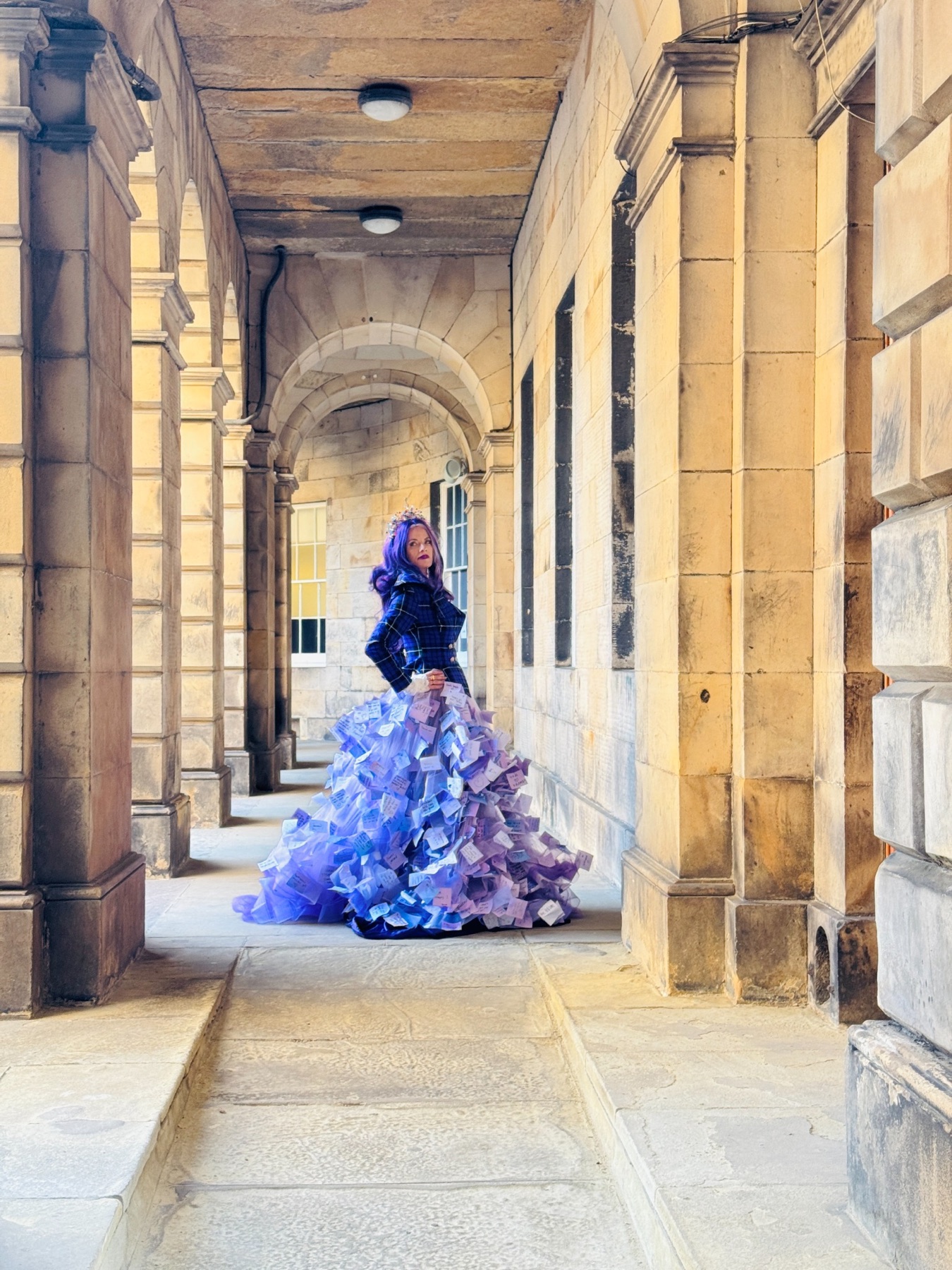 Janelle wearing the Purple Threads skirt covered in handwritten notes beneath a stone archway